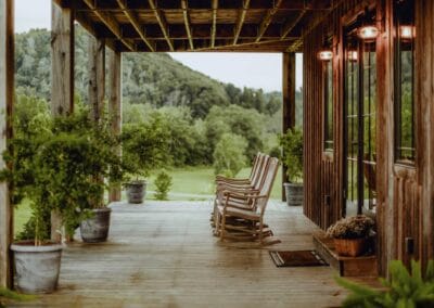 A long wooden porch with rocking chairs at The Lodge at Crooked River.