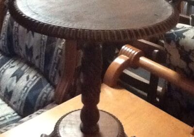 A round wooden side table at R & J's Emporium & Woodworking.